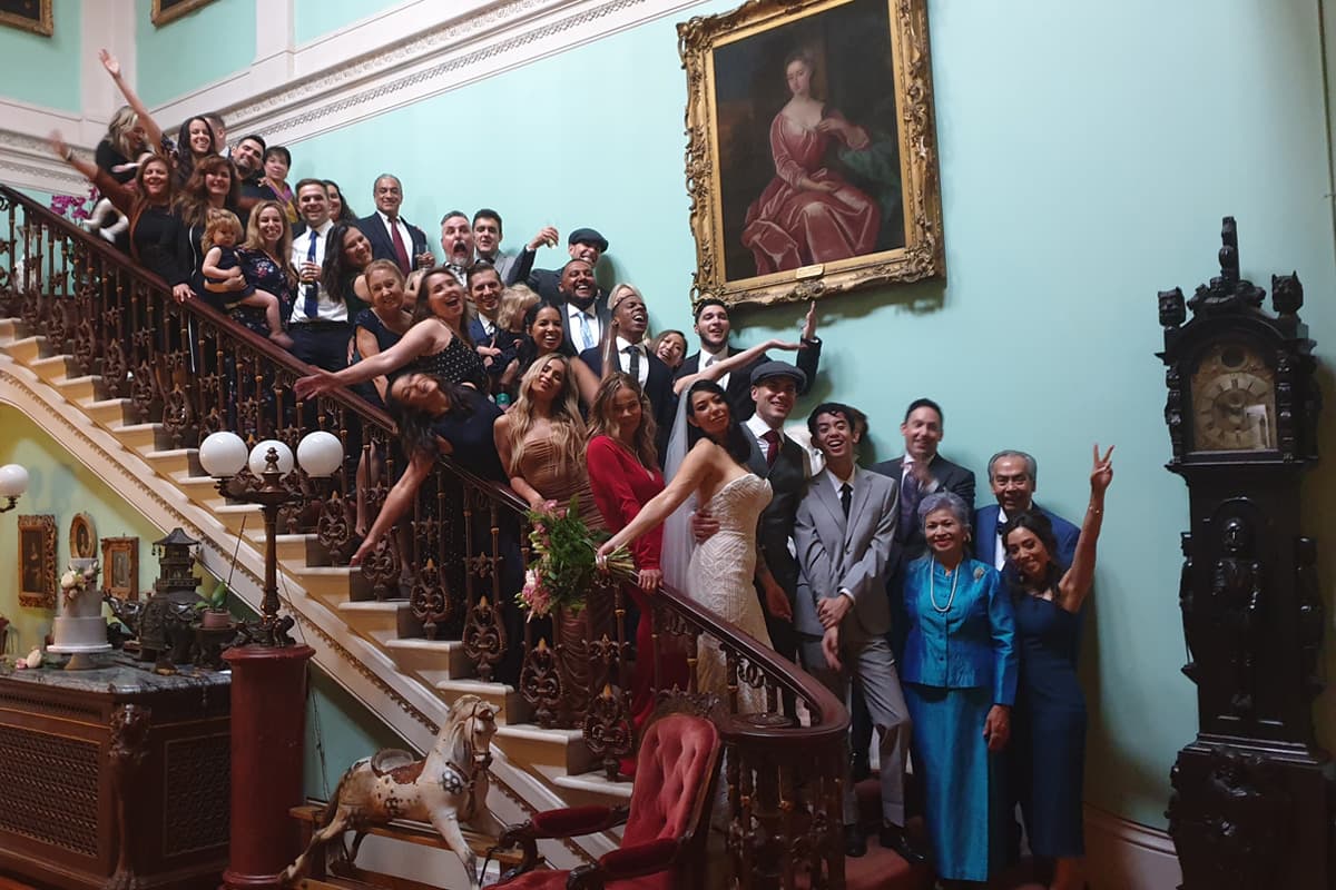 Group wedding photo on the stairs of Temple House