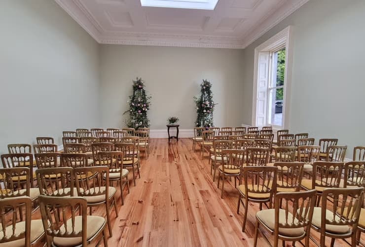Indoor ceremony room set with chairs and flowers at Temple House